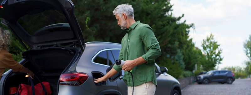 A man charging his EV using home EV charging software.