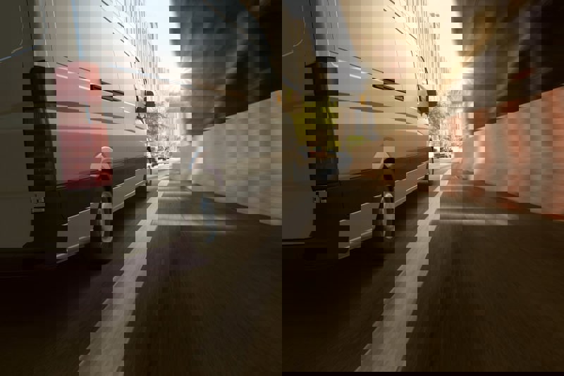 An electric car powered by fleet charging solutions driving through a city.