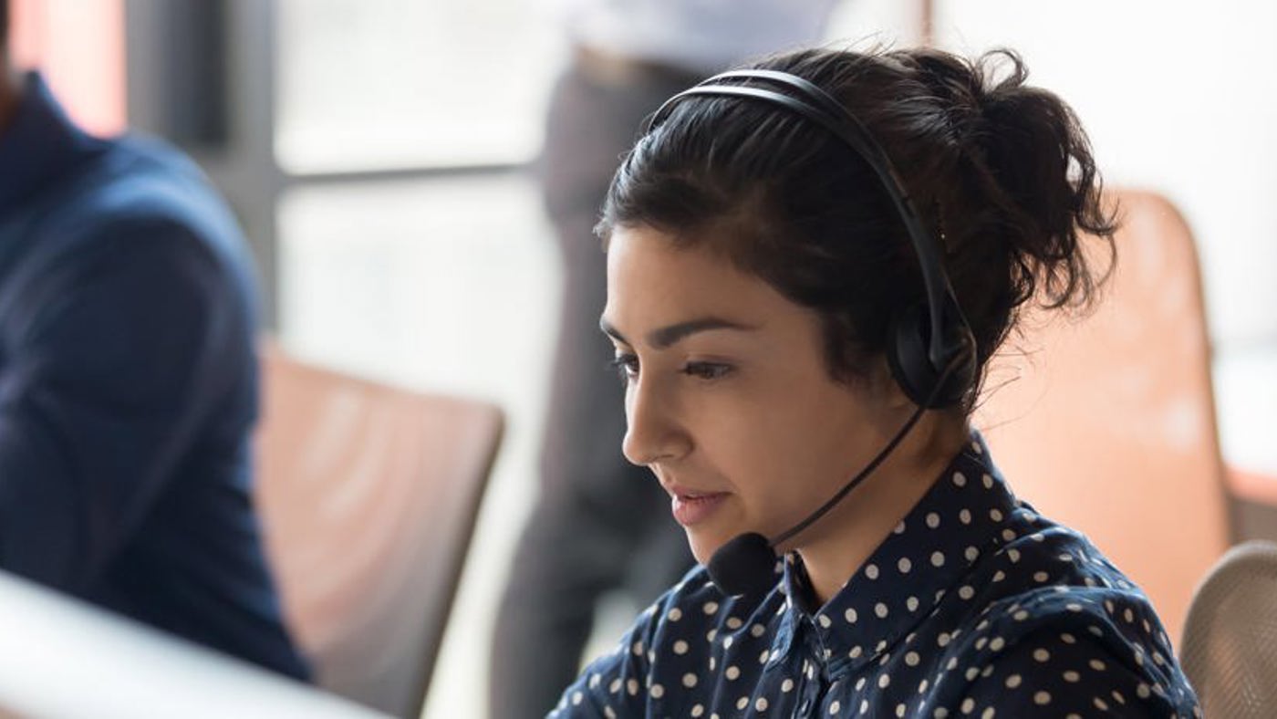 EV Charging Stations: Customer Service Line operator at desk with headset on.