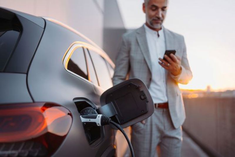 A man charging his ev driver app to charge his car.
